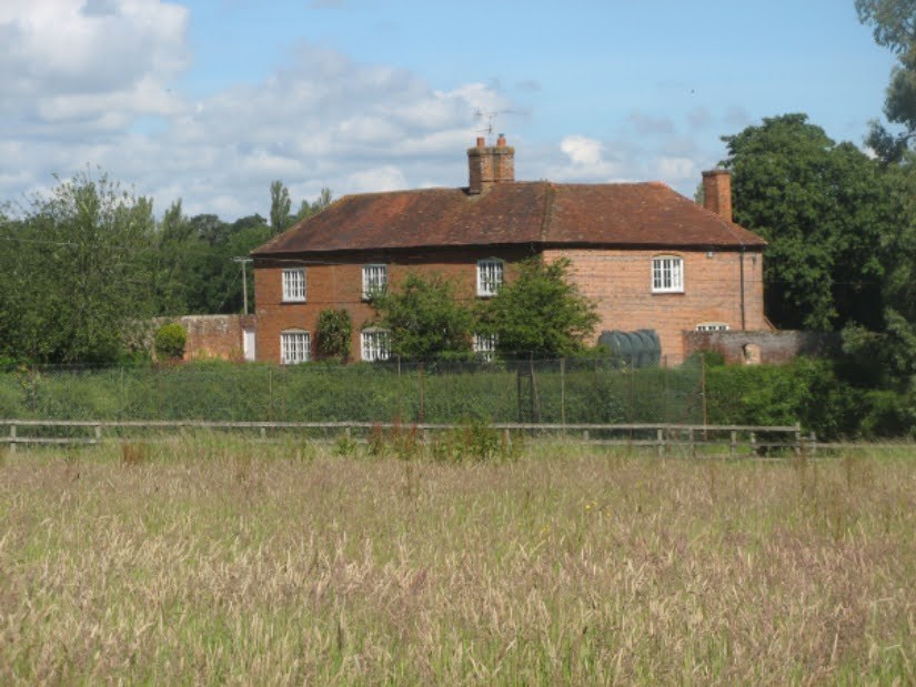 Red-brick farmhouse across a field